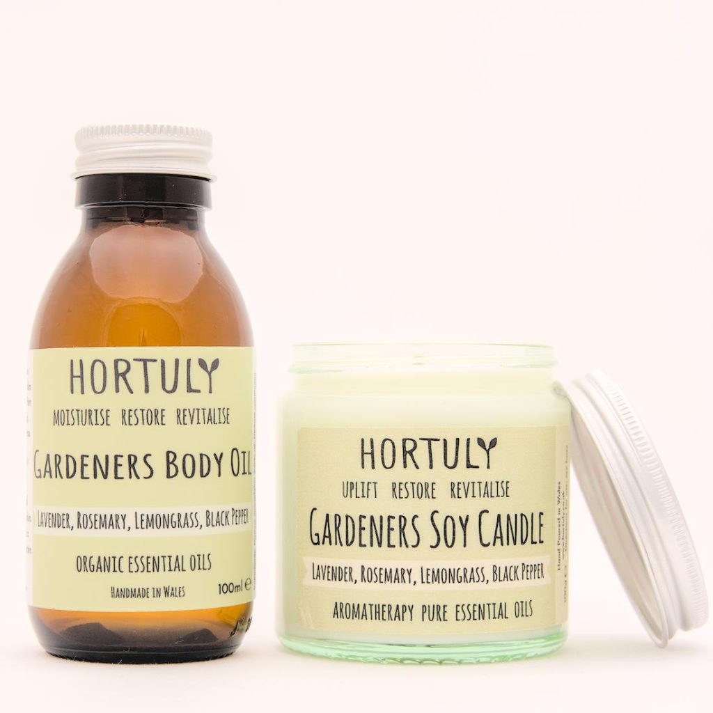 Natural, organic, Vegan skincare 
and Aromatherapy Home Fragrance. Hortuly Gardeners vegan body oil contained in an amber bottle with aluminium lid together with Hortuly Gardeners aromatherapy soy candle in a clear glass jar with an aluminium lid.